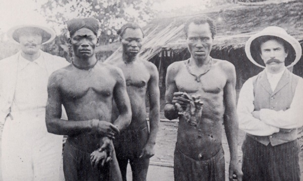 brit misszionáriusok kongói férfiak társaságában, akik az ABIR társaság milíciája által levágott kezeket mutatnak